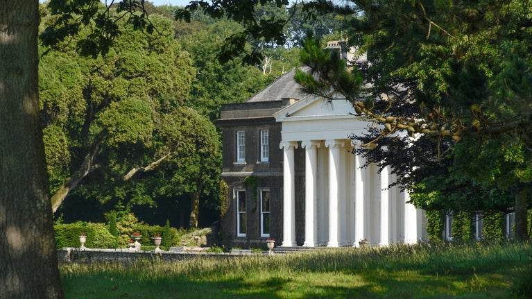 View of the Georgian house through the trees at Trelissick, Cornwall